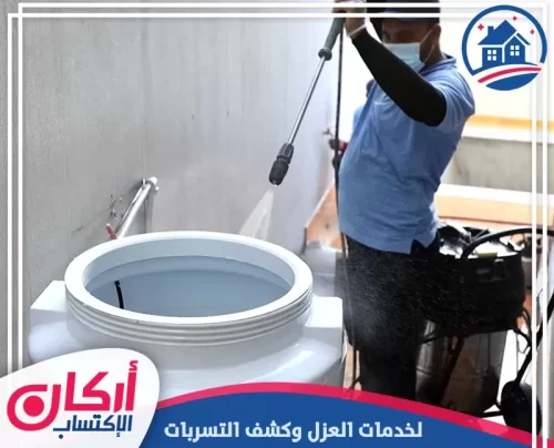 فني متخصص يغسل جدران الخزان بمعدات تنظيف حديثة.
