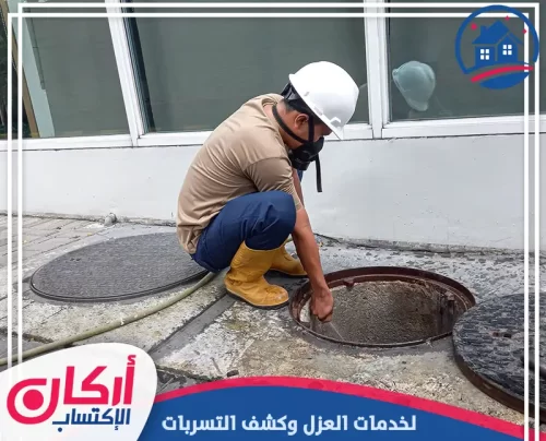 فني متخصص يقوم بعملية فحص لبالوعة صرف صحي رئيسية في منطقة خارجية.